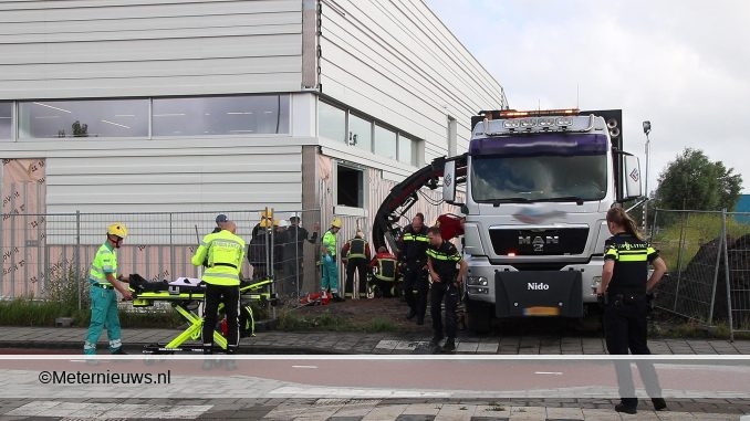 MAN BEKNELD ONDER PLAAT BOUWTERREIN GRONINGEN