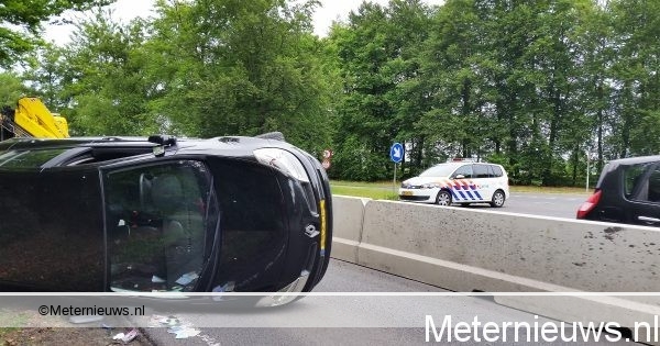 Auto op de kant na botsing met verkeersgeleider in Emmen.
