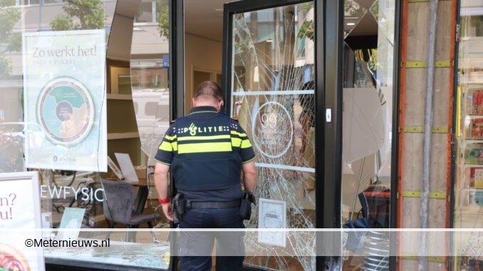 auto in de achteruit en ramt scooter fiets en voorpui winkel Groningen