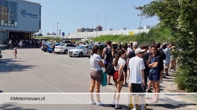 file wachtende mensen voor zwembad in Groningen